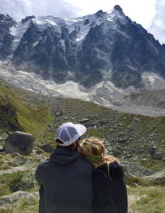 A photo of a couple sitting together in the mountains