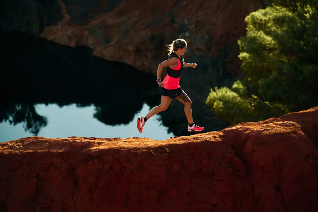 A photograph of a woman running along a ridge