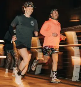 A photograph of two people running at night