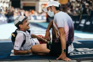 A photo of Kilian Jornet and another man at the finish line collapsed