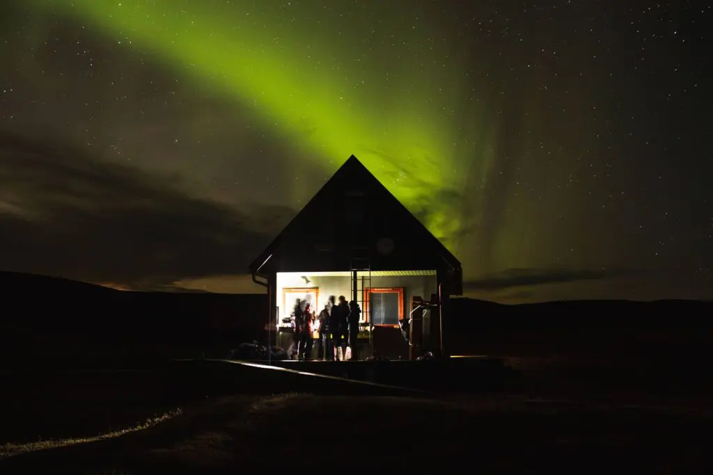 A photograph of a hut among the Northern Lights