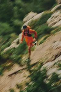 A photo of a man running downhill on trails