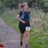 Woman running on a trail with a race bib